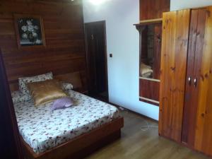 a bedroom with a bed and a cabinet at Casa DAOS in Nucşoara
