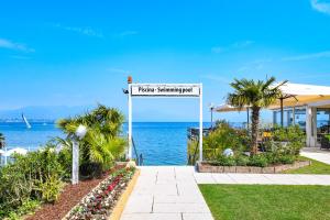 una señal para un resort con el océano en el fondo en Lido International, en Desenzano del Garda