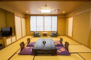 einen Konferenzraum mit einem Tisch und Stühlen sowie einem TV in der Unterkunft Yuzawa Grand Hotel in Yuzawa