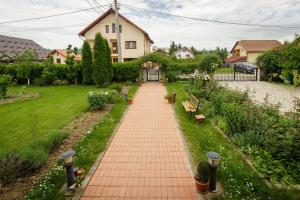 a brick walkway in a yard with benches at Casa Florilor in Curtea de Argeş