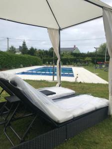 a swing bed under a canopy next to a pool at Villas Las Catedrales in Ribadeo