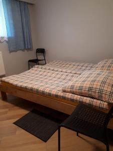 a bed in a room with a chair next to it at Bursztynowa Wyspa in Gdańsk