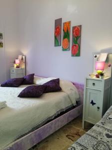 a bedroom with a bed and two night stands with lamps at Casa della nonna in Riposto
