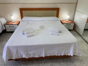een slaapkamer met een groot wit bed met 2 lampen bij Playa Apartment in Catania