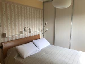 a bedroom with a bed with white sheets and a lamp at Palm Garden Apartment in Kastav