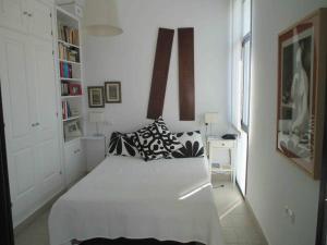 - une chambre blanche avec un grand lit blanc dans l'établissement Preciosa duplex en el Rompido, à El Rompido