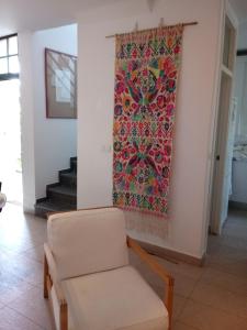 a chair in a room with a painting on the wall at Preciosa duplex en el Rompido in El Rompido +23 photos