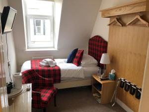 1 dormitorio pequeño con 1 cama y 1 silla en Montague Guest House en St Andrews