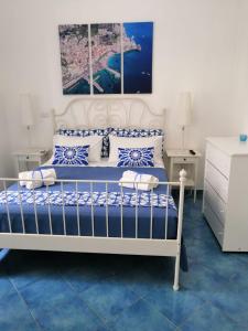 a bedroom with a white bed with blue and white pillows at Velia34 in Salerno