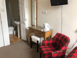 a room with a table and a chair and a mirror at Montague Guest House in St. Andrews