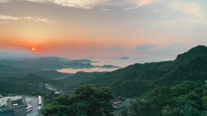 九份的住宿－九份麗景民宿，山 ⁇ 和湖泊的山谷的日落