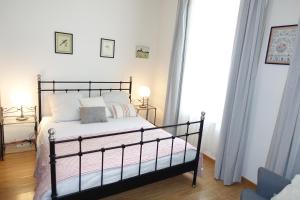 una camera da letto con letto nero e cuscini bianchi di Appartement Cosy et Lumineux idéalement placé a Boulogne-sur-Mer