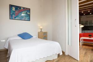 - une chambre avec un lit blanc et une chaise rouge dans l'établissement OLYMPIC VILLAGE, à Barcelone