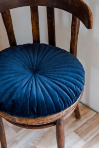 a wooden chair with a blue pillow on it at Casa Carminatti Apartments in Split