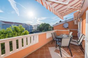 a patio with a table and chairs on a balcony at Apartments Julijana in Novalja