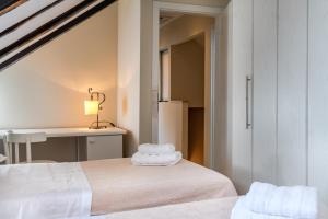 1 dormitorio con 2 camas blancas y escritorio en Casa Carminatti Apartments, en Split