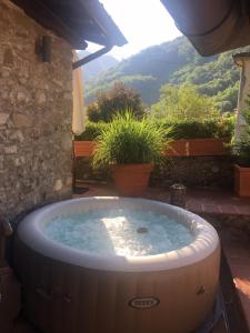 a hot tub in a yard with a view at River Idyll in Bagni di Lucca