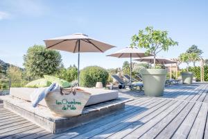 - deux lits sur une terrasse en bois avec des parasols dans l'établissement Hotel Les Chambres de Mila, à Bonifacio