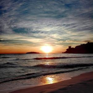 een zonsondergang op een strand met de oceaan bij La terrazza sul mare in Marina di Camerota