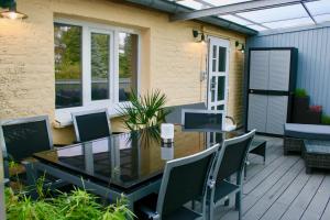 a patio with a glass table and chairs at Het Mergelhoek 2 in Vaals