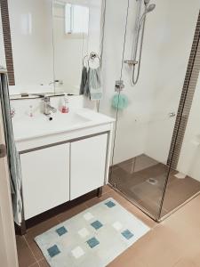 ein Badezimmer mit einem weißen Waschbecken und einer Dusche in der Unterkunft Stylish Private Bathroom-Luxurious modern big home in Epping