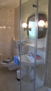 un bagno con doccia, lavandino e WC di Ferienhaus Windegge a Hirschegg Altre 20 foto