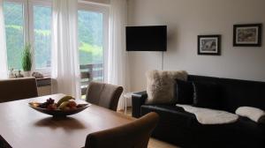 una sala de estar con una mesa con un bol de fruta. en Ferienhaus Windegge, en Hirschegg