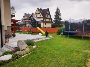 a yard with a playground and a house at u Sabiny in Białka Tatrzańska