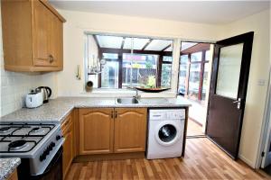 een keuken met een wastafel en een wasmachine bij St Andrews Golf and holiday home in St Andrews
