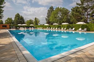 a large swimming pool with chairs and umbrellas at Golf Club Margara in Fubine