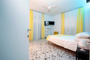 Un dormitorio con una cama y un televisor. en Plinio Seniore, en Castellammare di Stabia