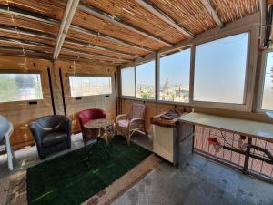 ein Zimmer mit Stühlen, einem Tisch und einigen Fenstern in der Unterkunft Apartment of Aamer(old city) in Nazareth