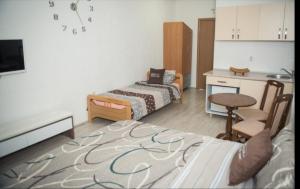 Habitación con 2 camas, mesa y cocina. en VIK Apartments, en Vinica