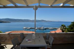 a table on a balcony with a view of a harbor at Heliades Maisonettes in Mythimna