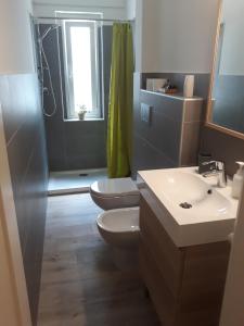 a bathroom with a toilet and a sink and a shower at Residence Sole in Trieste