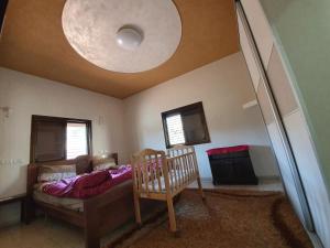 ein Schlafzimmer mit einem Bett und einem Kinderbett in einem Zimmer in der Unterkunft Apartment of Aamer(old city) in Nazareth