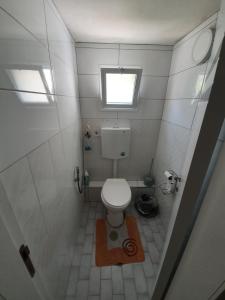 ein kleines Bad mit einem WC und einem Fenster in der Unterkunft Apartment of Aamer(old city) in Nazareth
