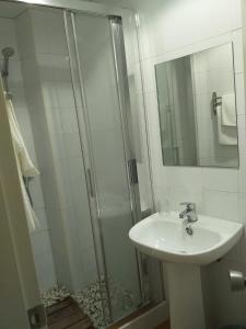 uma casa de banho com um lavatório e um chuveiro em Pensión Juan Pedro em Roquetas de Mar