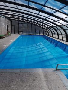 a large swimming pool with blue water in a building at Park Miedzywodzie in Międzywodzie