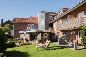 a yard with a gazebo and a house at Suiten-Hotel mare Langeoog in Langeoog