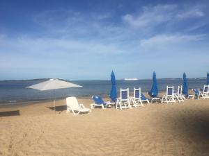 un grupo de sillas y sombrillas en una playa en Torre del mar, en Punta del Este