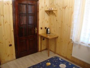 een kamer met een houten deur en een tafel met een telefoon bij Сердце Каньона in Kamjanets-Podilsky +13 foto's