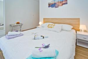 ein Schlafzimmer mit einem weißen Bett und Handtüchern darauf in der Unterkunft Sweet Dreams in Hvar