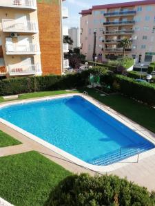 a swimming pool in front of a building at Faraon Park in La Pineda