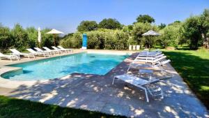 a swimming pool with lounge chairs and umbrellas at Il Mulino della Signora Luxury country House in Frigento