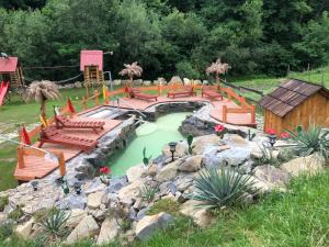 un jardín con piscina y un parque infantil con bancos en Agroturystyka Paradiso, en Ropa