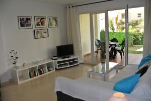 sala de estar con sofá, TV y mesa en Casas del Mar Bajo con vista, en Mijas