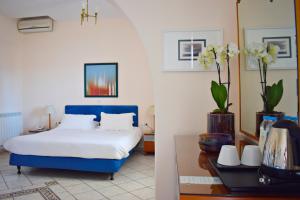 Un dormitorio con una cama azul y blanca y una mesa. en Hotel Adonis, en Mykonos ciudad 97 fotos más