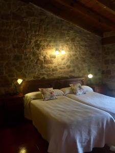 a hotel room with a bed and a lamp at Hotel Rural Las Nubes in Salas de los Infantes