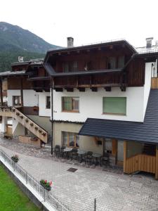 an external view of a building with tables and chairs at Locanda Da Pierina in Santo Stefano di Cadore